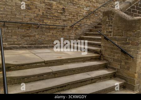 Marches en pierre victorienne à l'extérieur du moulin à sels à Saltaire, Yorkshire. Les ouvriers de l'usine ont grimpé les marches pour atteindre le trottoir au-dessus. Banque D'Images