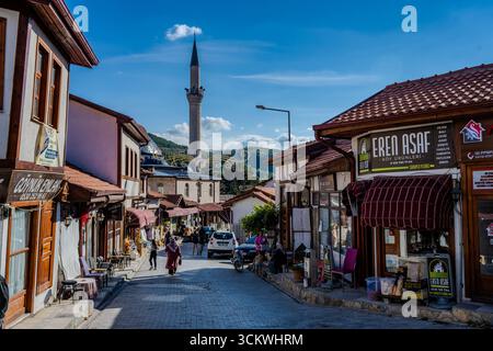 Les gens marchent le long d'une rue traditionnelle de style ottoman avec des boutiques et une vue sur la mosquée Gazi Süleyman Pacha dans la ville historique de Göynük, Bolu Provi Banque D'Images