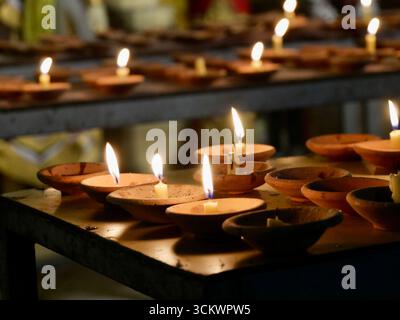 lampes à huile d'argile avec des bougies allumées dans un temple bouddhiste Banque D'Images