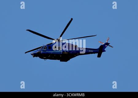 L'hélicoptère pH-PXY de la police nationale néerlandaise Leonardo AW139 passe au-dessus d'Amsterdam, pays-Bas pendant la voile 2025, livrée bleue et nacelles d'équipement visibles. Banque D'Images