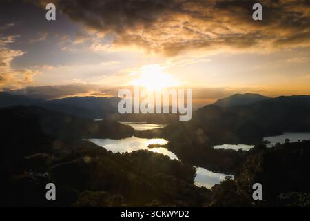 Un coucher de soleil à couper le souffle sur le bassin versant du réservoir Feitsui à Shiding, New Taipei City, Taiwan, avec des rayons dorés illuminant les collines ondoyantes A. Banque D'Images