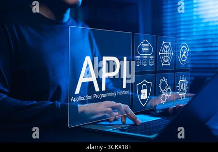 Concept d'interface de programmation d'applications API. Un programmeur tape sur un ordinateur portable, interagissant avec des icônes numériques représentant le développement API, la sécurité, Banque D'Images
