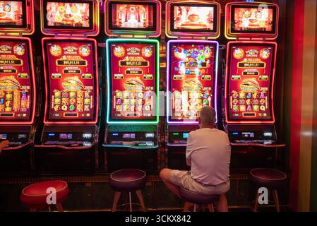 Homme solitaire jouant une machine à sous dans un casino Banque D'Images