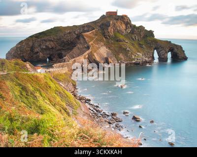 Soirée sereine à San Juan de Gaztelugatxe - Une vue de l'ermitage et escalier en pierre sinueux sur l'île rocheuse de Gaztelugatxe, entouré par th Banque D'Images