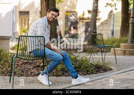 L'homme indien malade souffre d'inconfort douloureux mal d'articulation du genou, muscles des jambes, ne pouvait pas marcher à l'extérieur. Hispanique triste malade massant les genoux illn Banque D'Images
