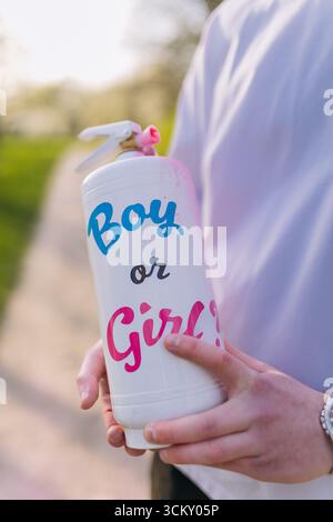 Le sexe révèle les détails de la fête avec le flacon pulvérisateur marqué garçon ou fille à l'extérieur Banque D'Images