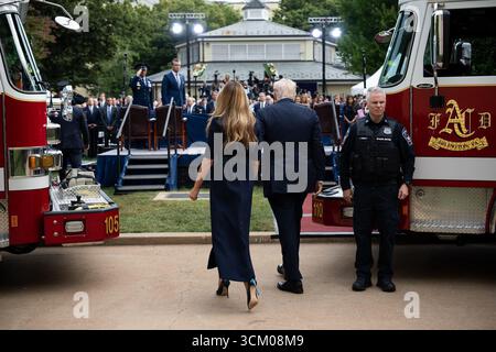 Le président Donald J. Trump et la première dame Melania Trump marchent vers la scène flanquée de camions de pompiers lors de la cérémonie d’observation du 11 septembre au Pentagone à Arlington, Virginie, le 11 septembre 2025. Banque D'Images