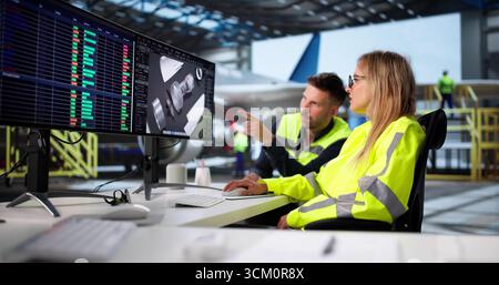 Jeune ingénieur réparant la pièce de moteur à réaction dans le hangar de maintenance d'avion. Femme Designer utilisant le logiciel 3D. Banque D'Images