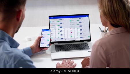 Homme utilisant un téléphone portable et un ordinateur portable pour postuler à des emplois Banque D'Images