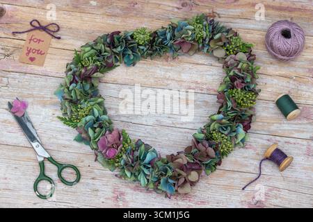 un arrangement romantique avec une couronne en forme de coeur de fleurs d'hortensia et de fleurs de lierre Banque D'Images