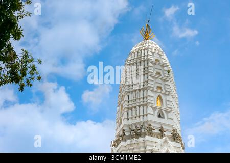 Wat Rakhang Kositaram à Bangkok, Thaïlande. Stupa blanc avec des statues de Bouddha dorées sous un ciel bleu vif, symbole de l'héritage et de la culture du temple thaïlandais. Banque D'Images