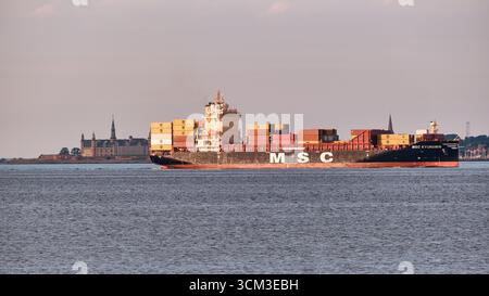 Helsingborg, Suède ; 13 août 2025 : porte-conteneurs MSC Kyungmin naviguant dans le détroit d'Oeresund avec visible à l'horizon, transportant des marchandises empilées cont Banque D'Images