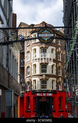 Un bâtiment en briques de plusieurs étages avec un rez-de-chaussée rouge, un panneau proéminent et un échafaudage sur la droite à Liverpool, Royaume-Uni. Banque D'Images