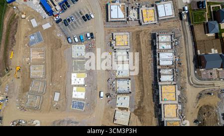 Une vue aérienne montre un chantier de construction avec plusieurs fondations, échafaudages, véhicules et matériaux de construction à Miller Homes à Catterick, au Royaume-Uni. Banque D'Images