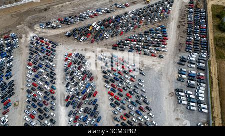 Une vue aérienne montre un grand terrain extérieur rempli de rangées de voitures stationnées, la plupart de couleur foncée, sur une surface de gravier à Copart yard à York, au Royaume-Uni. Banque D'Images