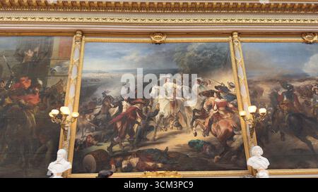 Un grand cadre doré orné entoure trois peintures de combat spectaculaires mettant en vedette la cavalerie, les soldats et les vêtements historiques. Deux bustes se tiennent à l'avant Banque D'Images