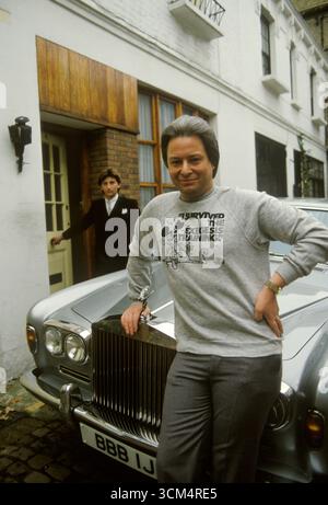 Robert D'Aubigny dont le vrai nom est Robert Fuller fondateur de l'exégèse, un culte des années 1970. Vu ici avec sa Rolls Royce devant sa maison Mew à Chelsea Londres. Le T-shirt dit - "J'ai SURVÉCU AU SÉMINAIRE D'EXÉGÈSE" L'homme en arrière-plan est son assistant personnel, (nom de famille Marcus) jouant à être son chauffeur. Londres, Angleterre des années 1972 1970 Royaume-Uni HOMER SYKES Banque D'Images