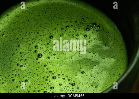 Mousse Matcha vibrante. Gros plan de matcha fraîchement fouetté avec une mousse Banque D'Images