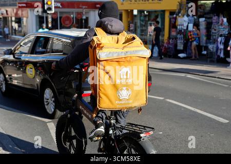 Il suffit de manger courrier sur un vélo électrique à Brighton, Royaume-Uni Banque D'Images