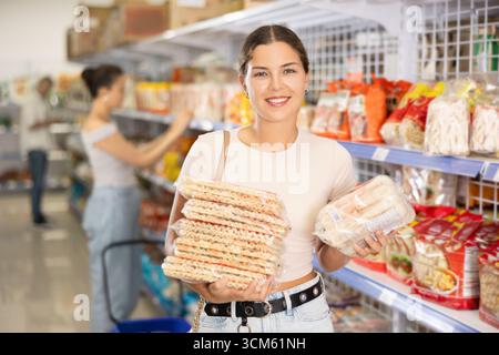 Jeune femme choisissant des nouilles en magasin Banque D'Images
