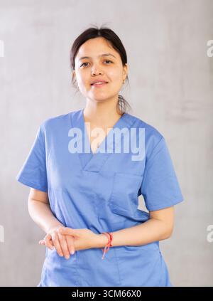 Professionnel confiant positif jeune médecin féminin en uniforme bleu Banque D'Images