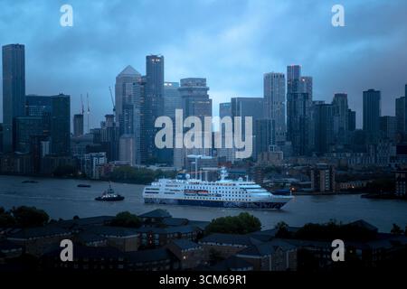 Londres, Royaume-Uni. 14 septembre 2025. Le navire de croisière MS Hamburg passe devant les bâtiments du parc d'activités de Canary Wharf en fin de soirée de dimanche. Construit en 1997, le navire de croisière de luxe de 144 mètres et 400 passagers appartient au groupe Conti et est actuellement exploité par la société allemande Plantours Kreuzfahrten (Plan Tours). Crédit : Guy Corbishley/Alamy Live News Banque D'Images