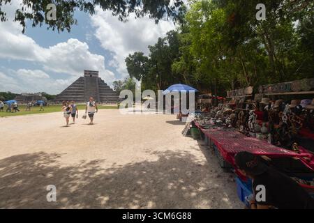 Vue panoramique sur la place principale du site archéologique de Chichen Itza avec les vendeurs d'artisanat touristique et temple kukulkan en arrière-plan Banque D'Images
