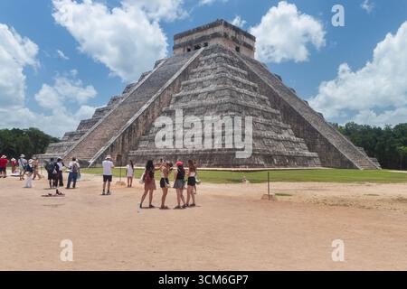 Un groupe de touristes prenant des photos devant le côté nord-ouest du temple maya kukulkan dans le site archéologique de Chichen Itza Banque D'Images