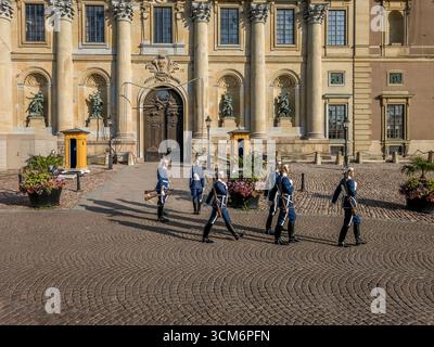 Des soldats royaux suédois en uniforme de tuniques bleues et des casques argentés changent de garde devant le Palais Royal de Stockholm en Suède Banque D'Images
