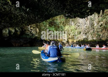 PHUKET, THAÏLANDE - 12 NOVEMBRE 2017 : groupe d'adultes faisant du kayak dans une grotte pittoresque avec des stalactites et de l'eau claire dans une aventure en plein air. Banque D'Images