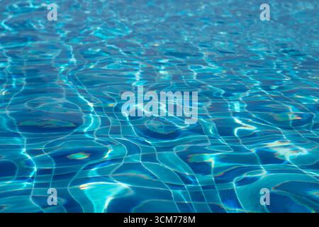 Lumière du soleil créant de belles ondulations sur la surface de l'eau de la piscine Banque D'Images