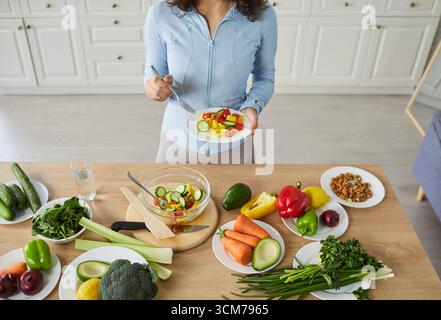 Vue aérienne de la femme préparant la salade dans la cuisine Banque D'Images