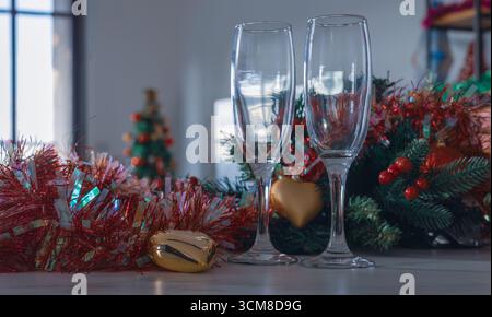 Deux verres à champagne vides avec guirlande de Noël, ornements et fond festif. Ambiance de célébration confortable, ambiance de vacances, espace de copie Banque D'Images