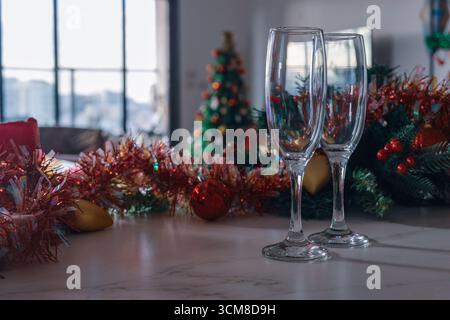 Deux verres à champagne vides avec guirlande de Noël, ornements et fond festif. Ambiance de célébration confortable, ambiance de vacances, espace de copie Banque D'Images
