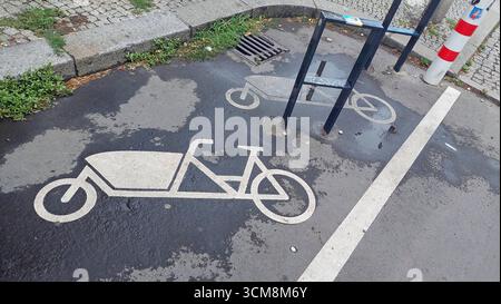 Pictogramme de vélo cargo pour marquer les espaces de stationnement pour vélos cargo sur asphalte mouillé Banque D'Images