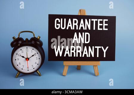 Garantie et texte de garantie avec chevalet et réveil sur fond bleu Banque D'Images
