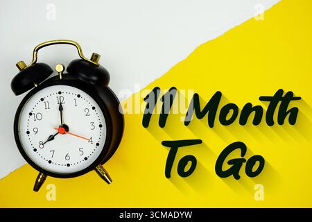 11 Month To Go texte et réveil sur fond jaune Banque D'Images