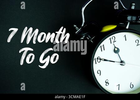 7 Month To Go texte et réveil sur fond noir Banque D'Images
