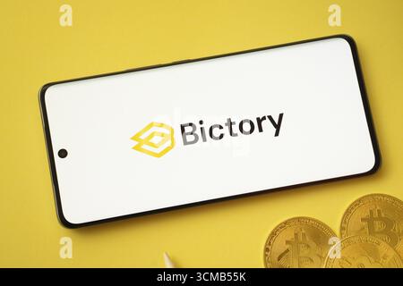 Dhaka, Bangladesh- 09 septembre 2025 : logo Bictory sur l'écran du smartphone près de Bitcoin coin et QR code sur fond Banque D'Images