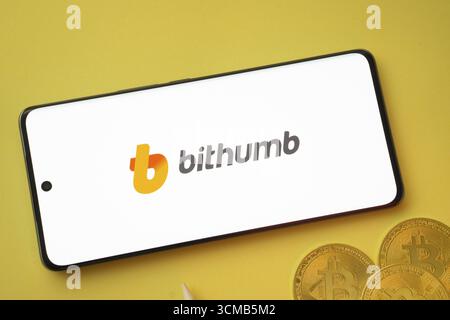 Dhaka, Bangladesh- 07 mai 2025 : logo Bithumb sur l'écran du smartphone près de Bitcoin coin et QR code sur fond Banque D'Images
