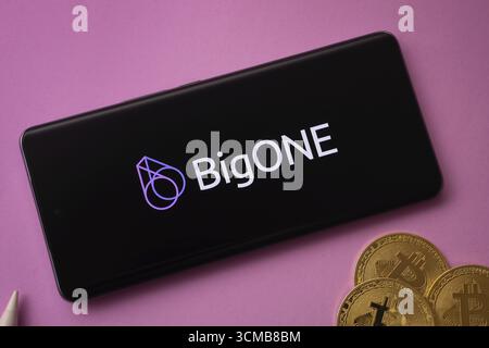 Dhaka, Bangladesh- 15 juin 2025 : logo bigONE sur l'écran du smartphone près de Bitcoin coin et QR code sur fond Banque D'Images