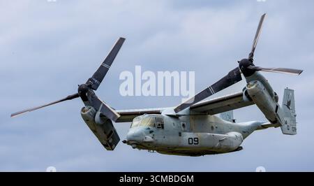 United States Marine corps MV-22 Osprey Tiltrotor avion militaire avec rotors en position de vol vers l'avant volant contre le ciel nuageux lors d'un spectacle aérien Banque D'Images