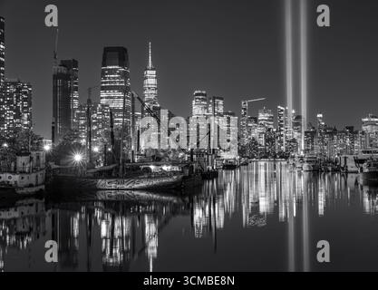 Vue nocturne monochrome de la ville de New York avec un hommage lumineux dans des faisceaux lumineux qui brillent dans le ciel comme mémorial du 11 septembre Banque D'Images
