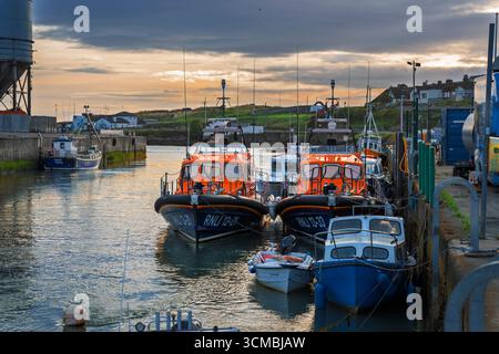 Paire de canots de sauvetage RNLI amarrés à Wicklow Harbour, Irlande, avec drapeau irlandais, équipement de sauvetage et fond de port. Banque D'Images