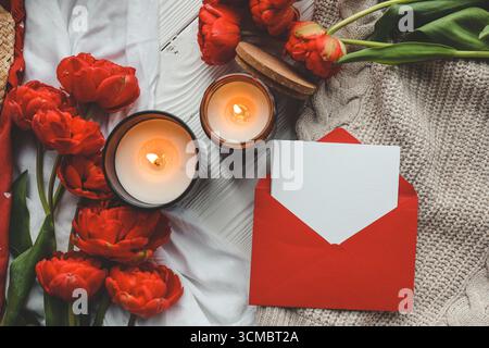 Carte de vœux dans une enveloppe rouge. Concept de fête des mères ou de Saint-Valentin. Place pour votre texte. Banque D'Images
