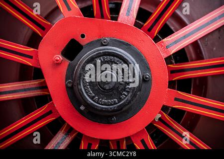 Gros plan d'une roue principale de machine à vapeur vintage avec des rayons rouges, jaunes et noirs à Coolgreany Vintage Parade. Banque D'Images