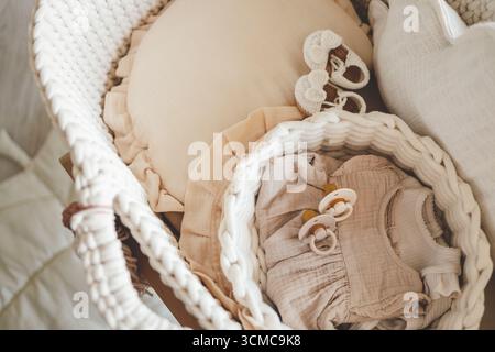 Chaussons tricotés et choses pour un nouveau-né dans le berceau. Banque D'Images