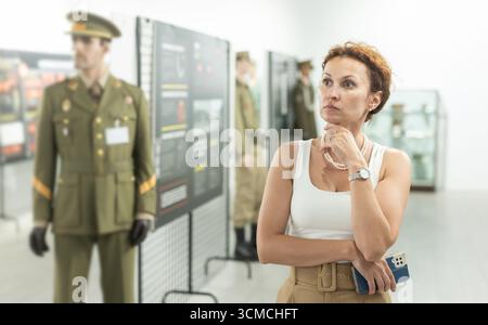 Femme d'âge moyen regardant des expositions dans le musée militaire Banque D'Images