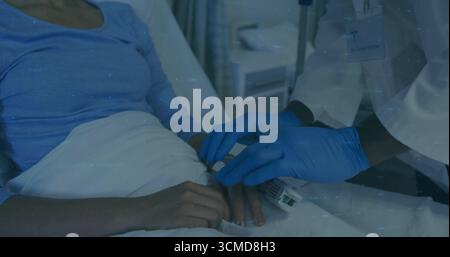 Clinicien appliquant le clip de l'oxymètre de pouls sur le doigt du patient dans le lit d'hôpital, avec moniteur, espace de copie Banque D'Images