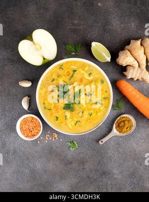 Soupe indienne Mulligatawny avec des ingrédients sur fond gris. Vue de dessus. Cuisine indienne. Banque D'Images